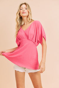 Fuchsia A V-Neck Dolman Short Sleeve Woven Blouse With Front Pleat Details
